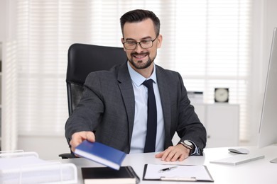 Photo of Smiling banker working at table in office