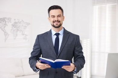 Photo of Portrait of smiling banker with notebook in office