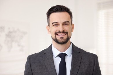 Photo of Portrait of smiling banker in suit indoors