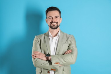 Photo of Portrait of smiling banker with crossed arms on light blue background