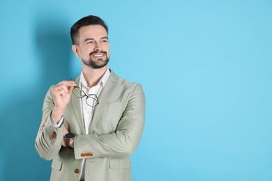 Photo of Portrait of smiling banker on light blue background. Space for text