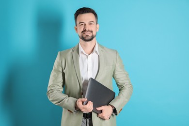 Photo of Smiling banker with laptop on light blue background