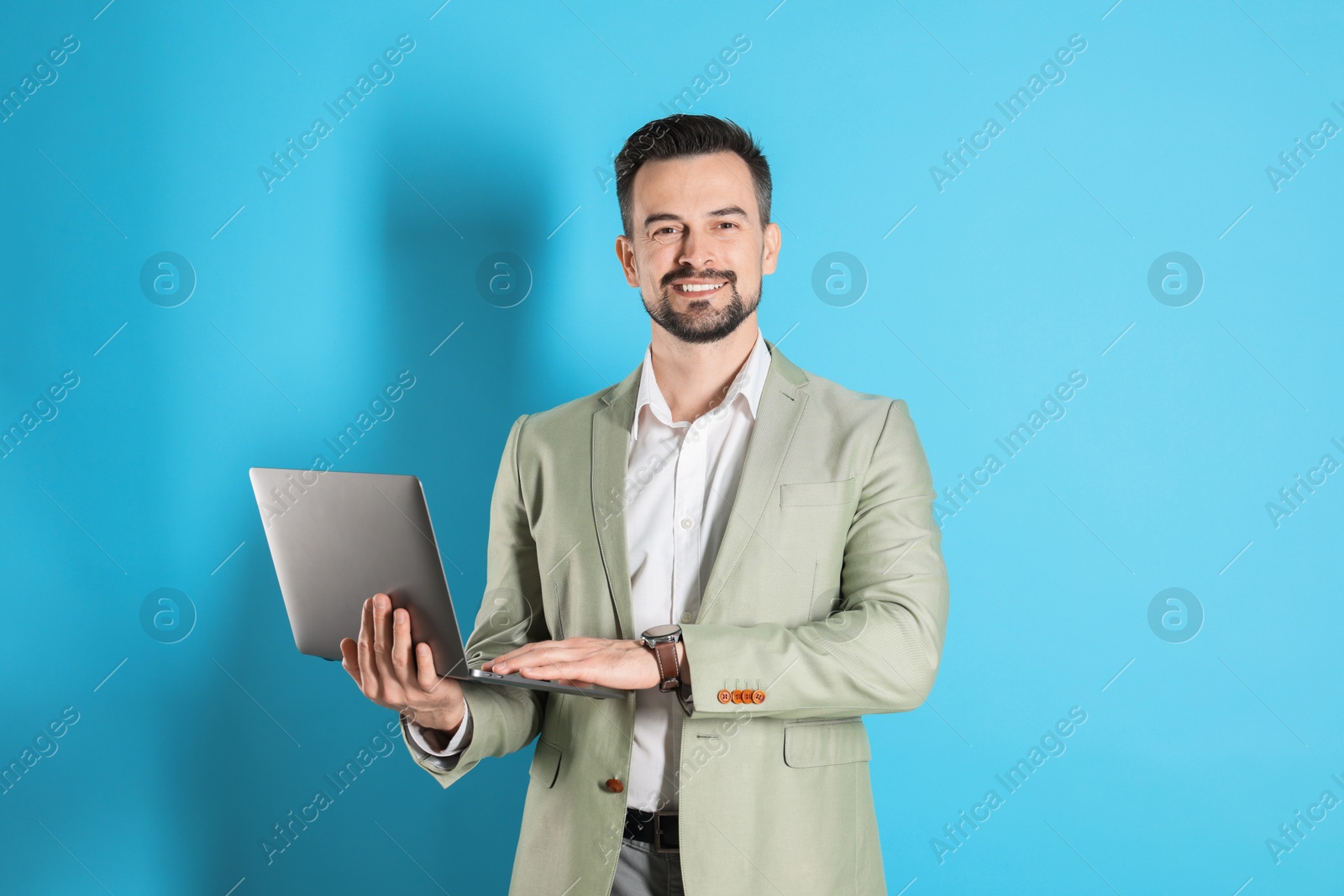 Photo of Smiling banker with laptop on light blue background