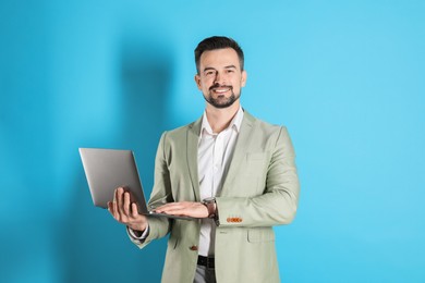 Photo of Smiling banker with laptop on light blue background