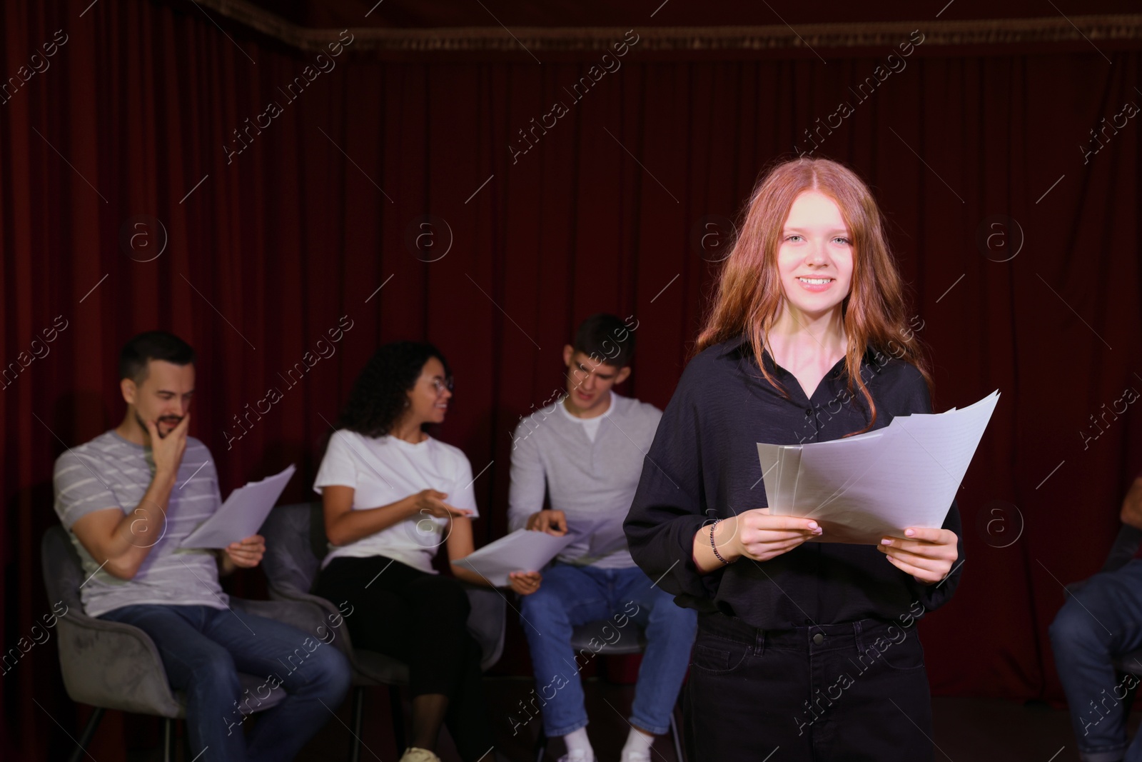 Photo of Professional actors reading their scripts during rehearsal in theatre