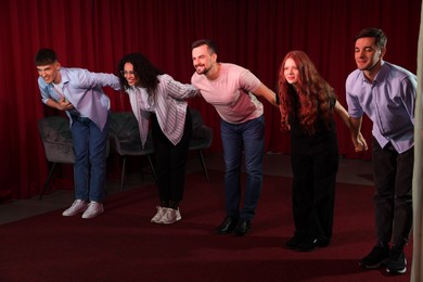 Photo of Professional actors bowing on stage in theatre