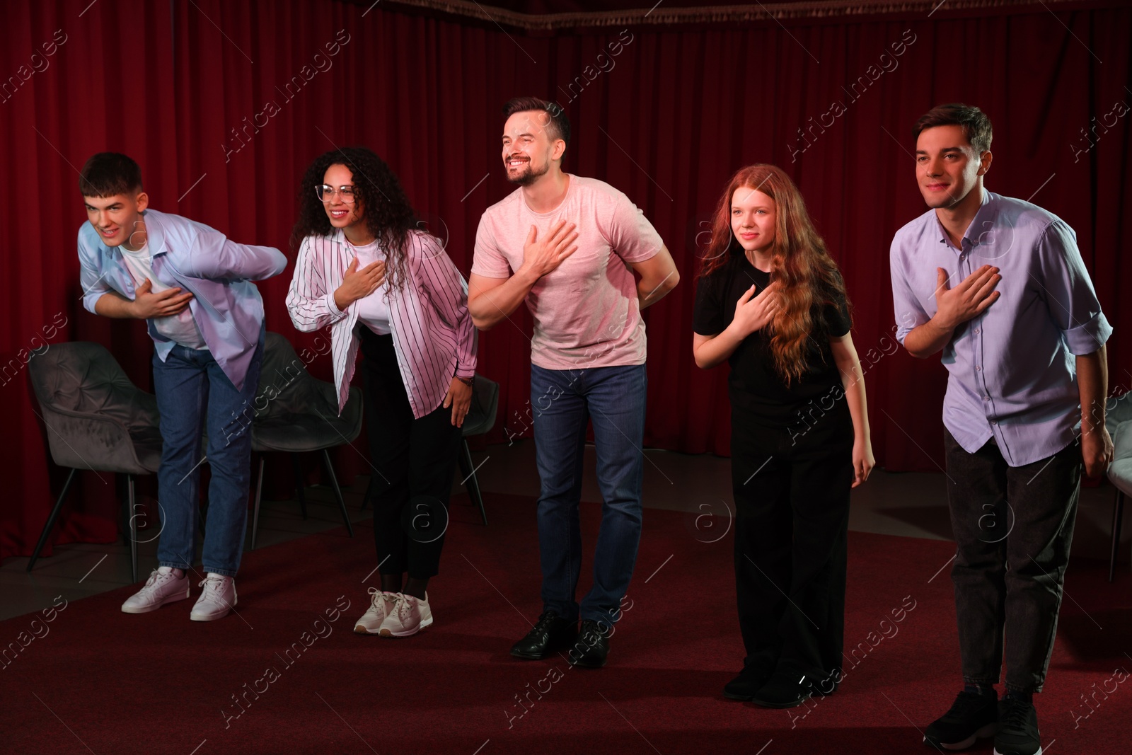 Photo of Professional actors bowing on stage in theatre