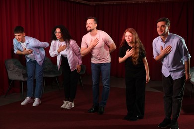 Photo of Professional actors bowing on stage in theatre