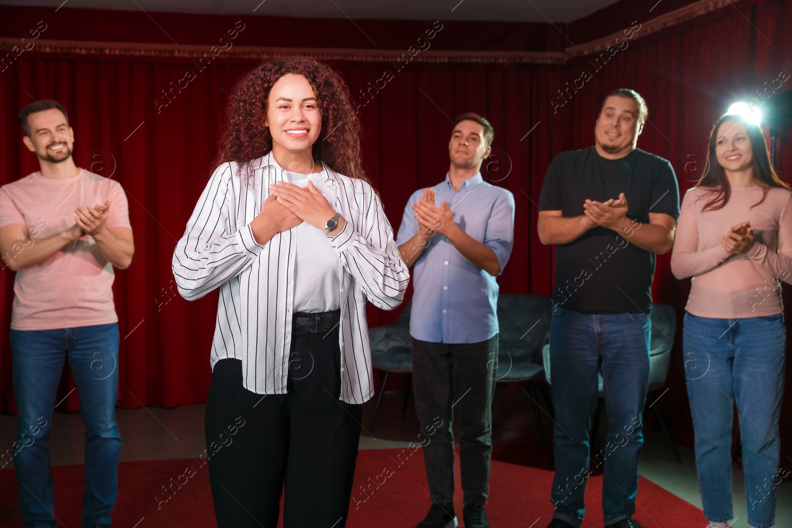 Photo of Professional actors bowing on stage in theatre