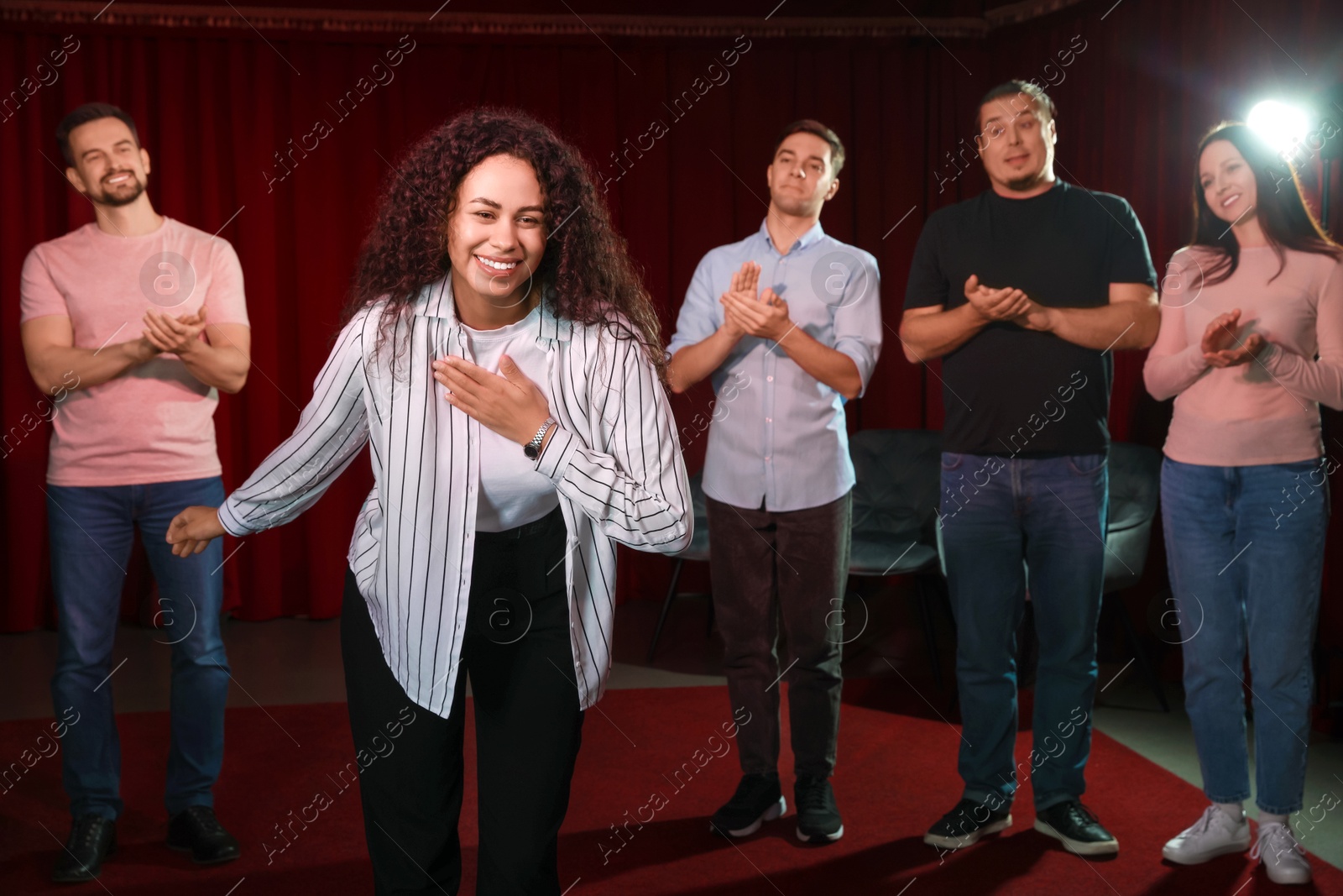 Photo of Professional actors bowing on stage in theatre