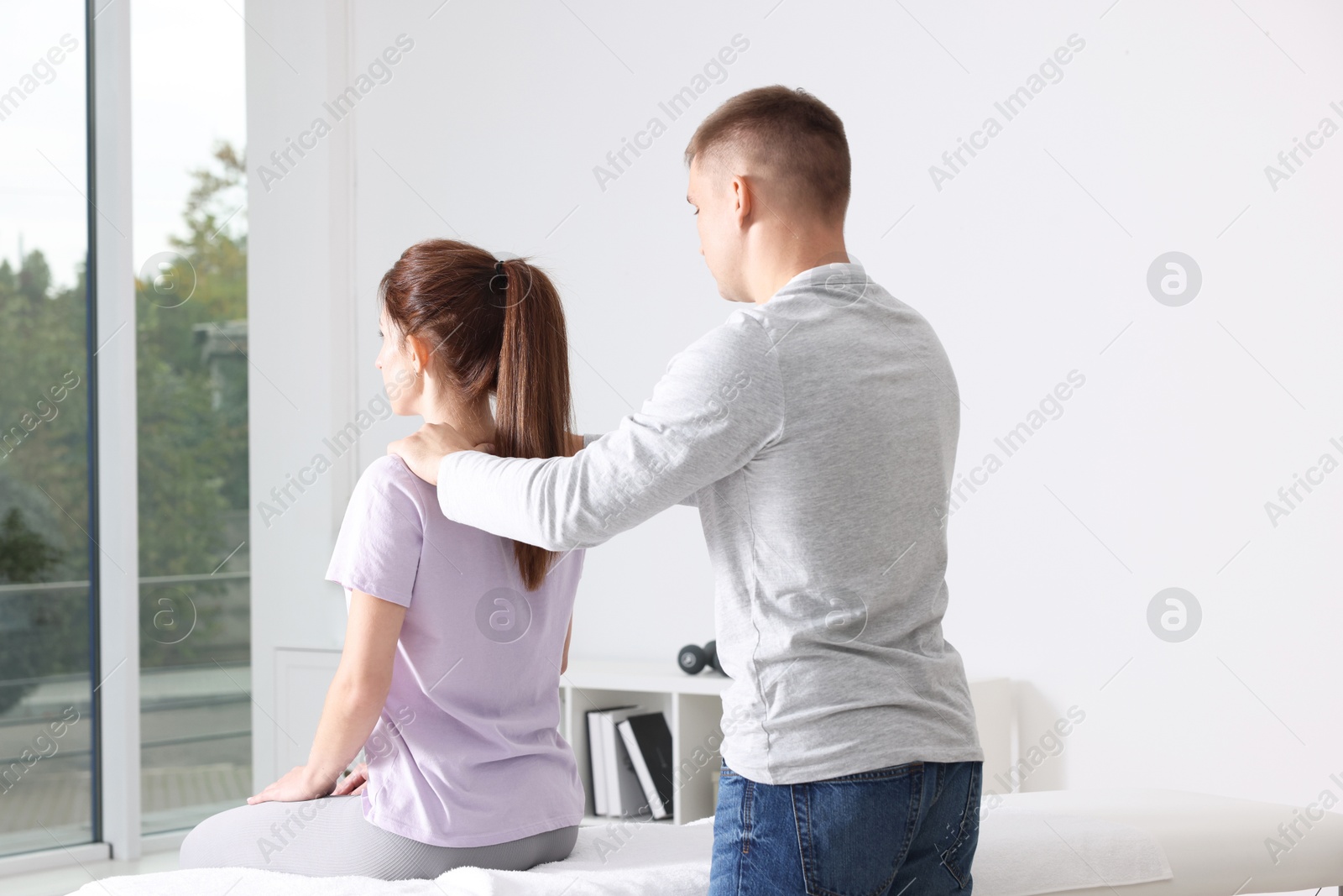 Photo of Osteopath working with patient in clinic. Manual therapy