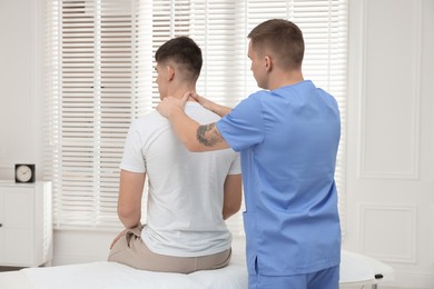 Photo of Osteopath working with patient in clinic. Manual therapy