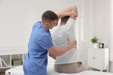 Photo of Osteopath working with patient in clinic. Manual therapy