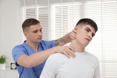 Photo of Osteopath working with patient in clinic. Manual therapy