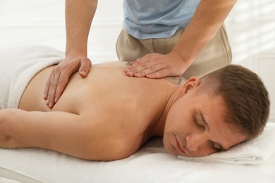 Photo of Massage therapist working with patient in clinic, closeup