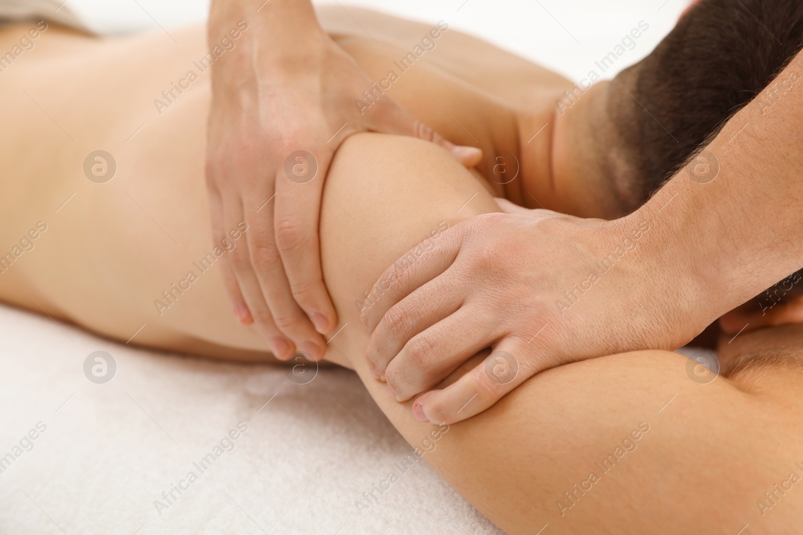 Photo of Massage therapist working with patient in clinic, closeup