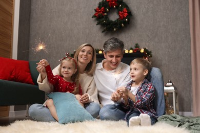 Lovely family with Christmas sparklers at home