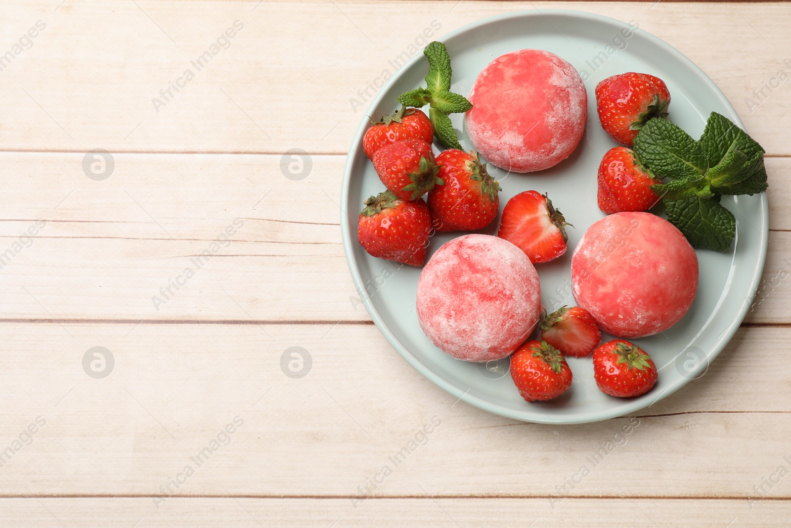 Photo of Delicious mochi, strawberries and mint on wooden table, top view. Space for text