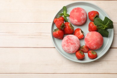 Photo of Delicious mochi, strawberries and mint on wooden table, top view. Space for text