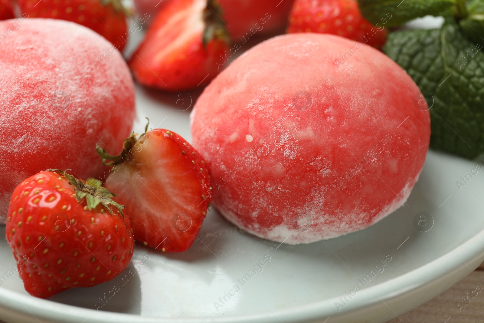 Photo of Delicious mochi, strawberries and mint on table, closeup