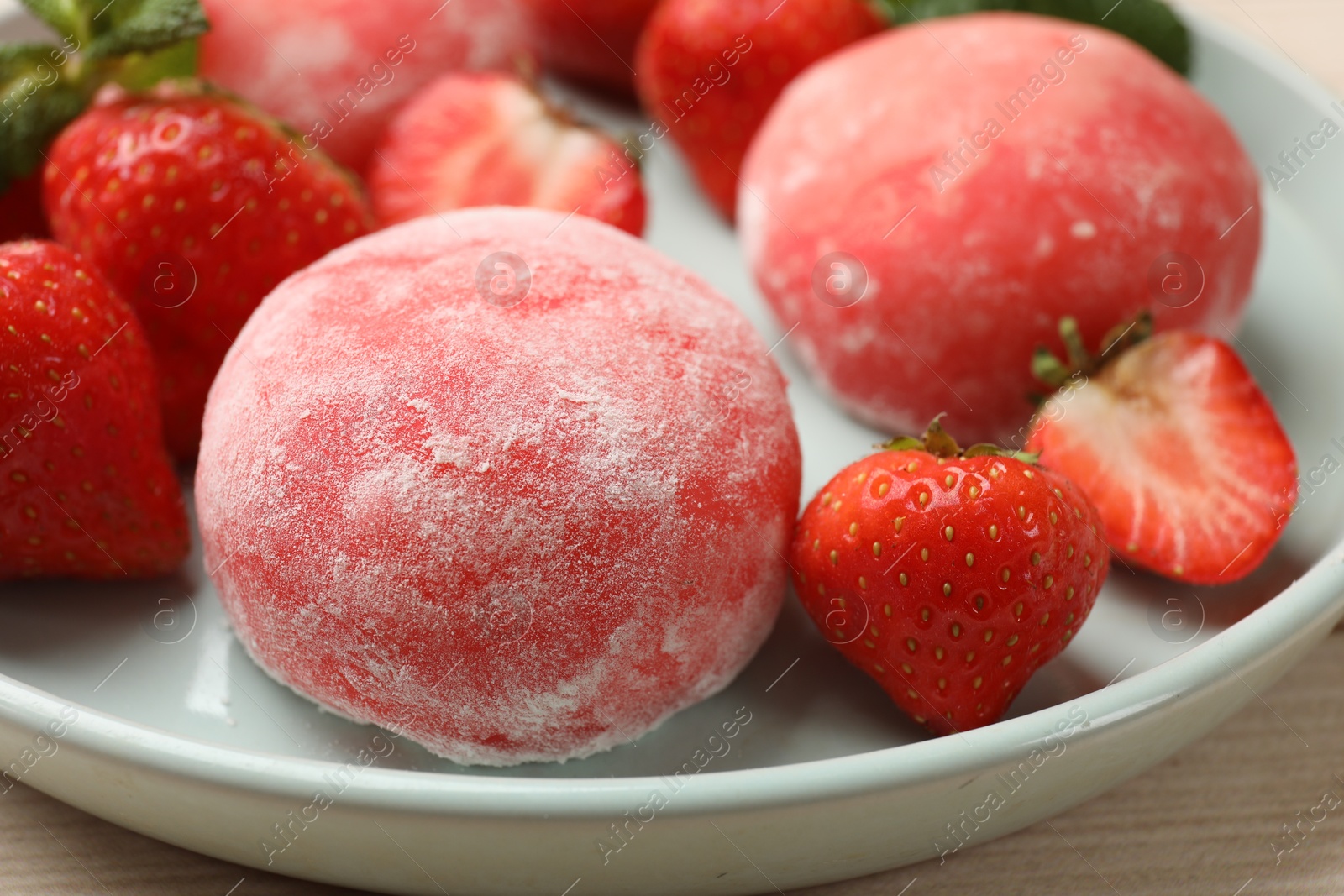 Photo of Delicious mochi and strawberries on table, closeup