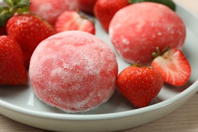 Photo of Delicious mochi and strawberries on table, closeup