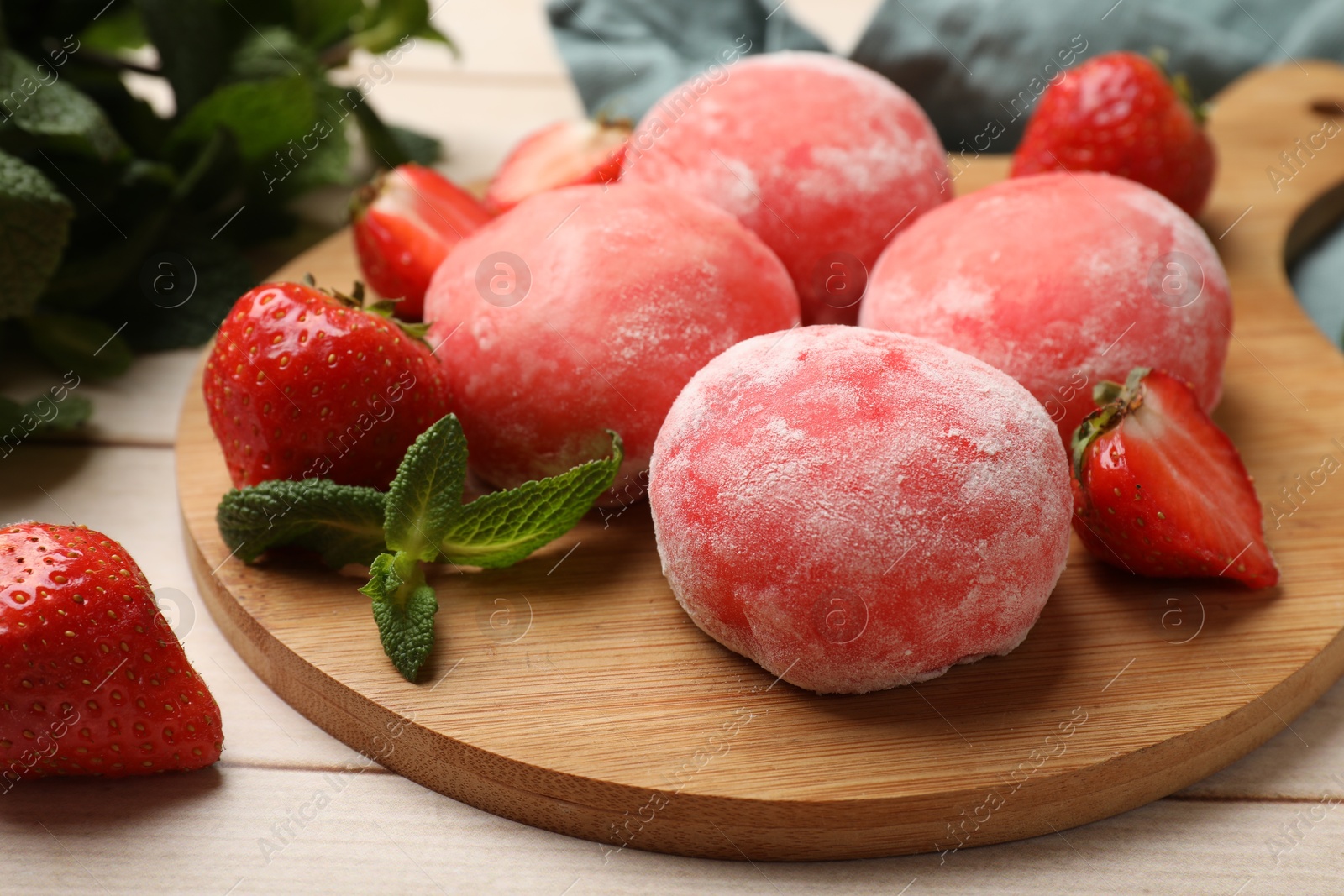 Photo of Delicious mochi, strawberries and mint on wooden table, closeup