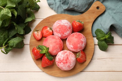 Photo of Delicious mochi, strawberries and mint on wooden table, flat lay