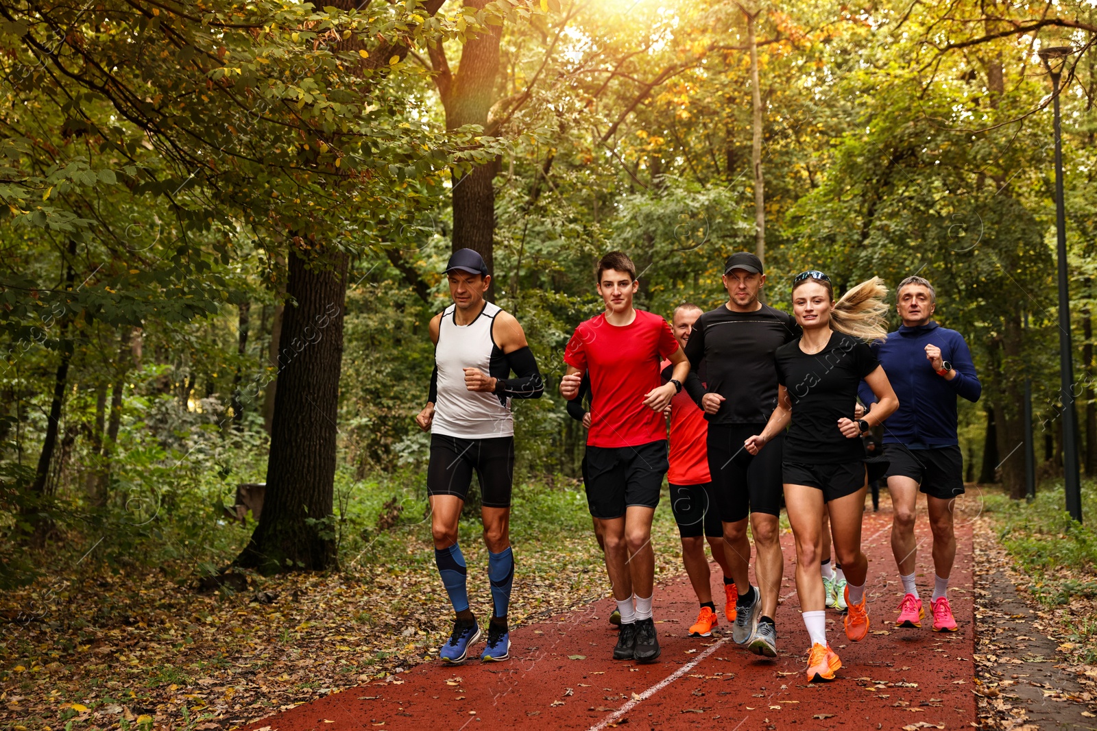 Photo of Group of people jogging together in park