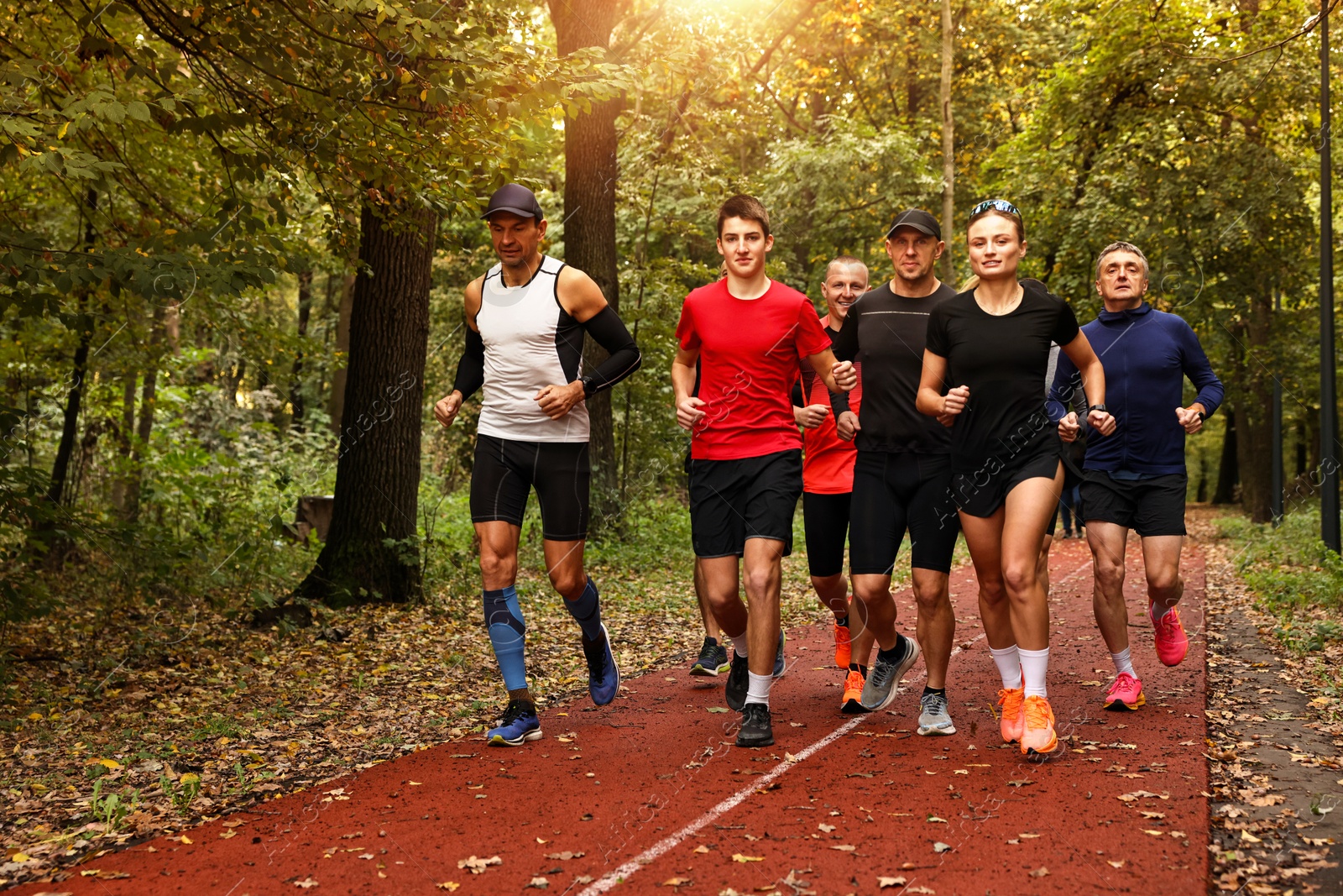 Photo of Group of people jogging together in park