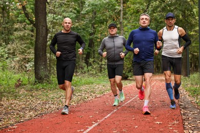 Photo of Group of people jogging together in park