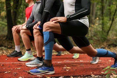 Photo of Group of people stretching in park, closeup