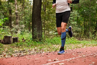 Photo of Athletic man running in park, closeup. Space for text