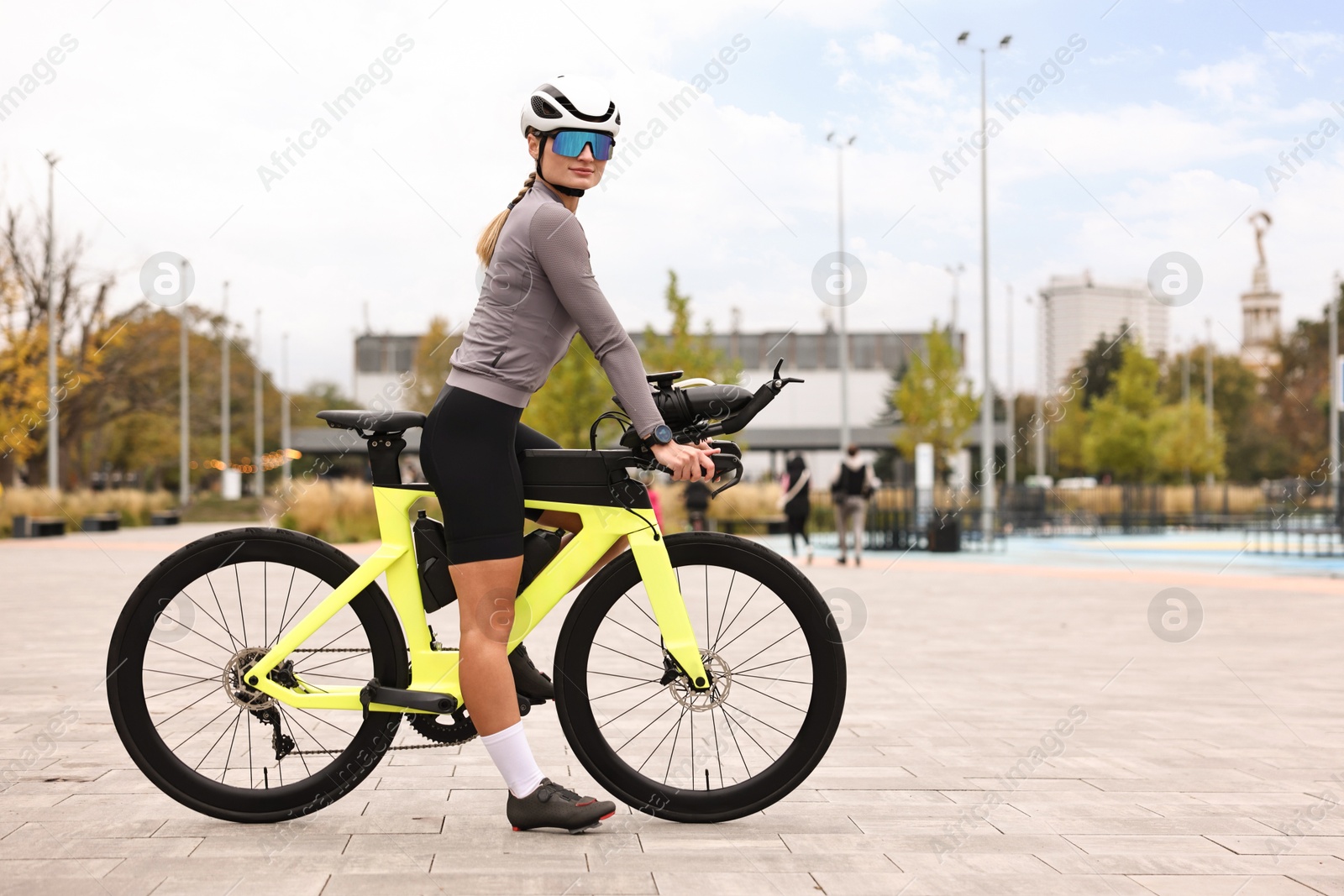 Photo of Young athletic woman with helmet and bicycle outdoors, space for text