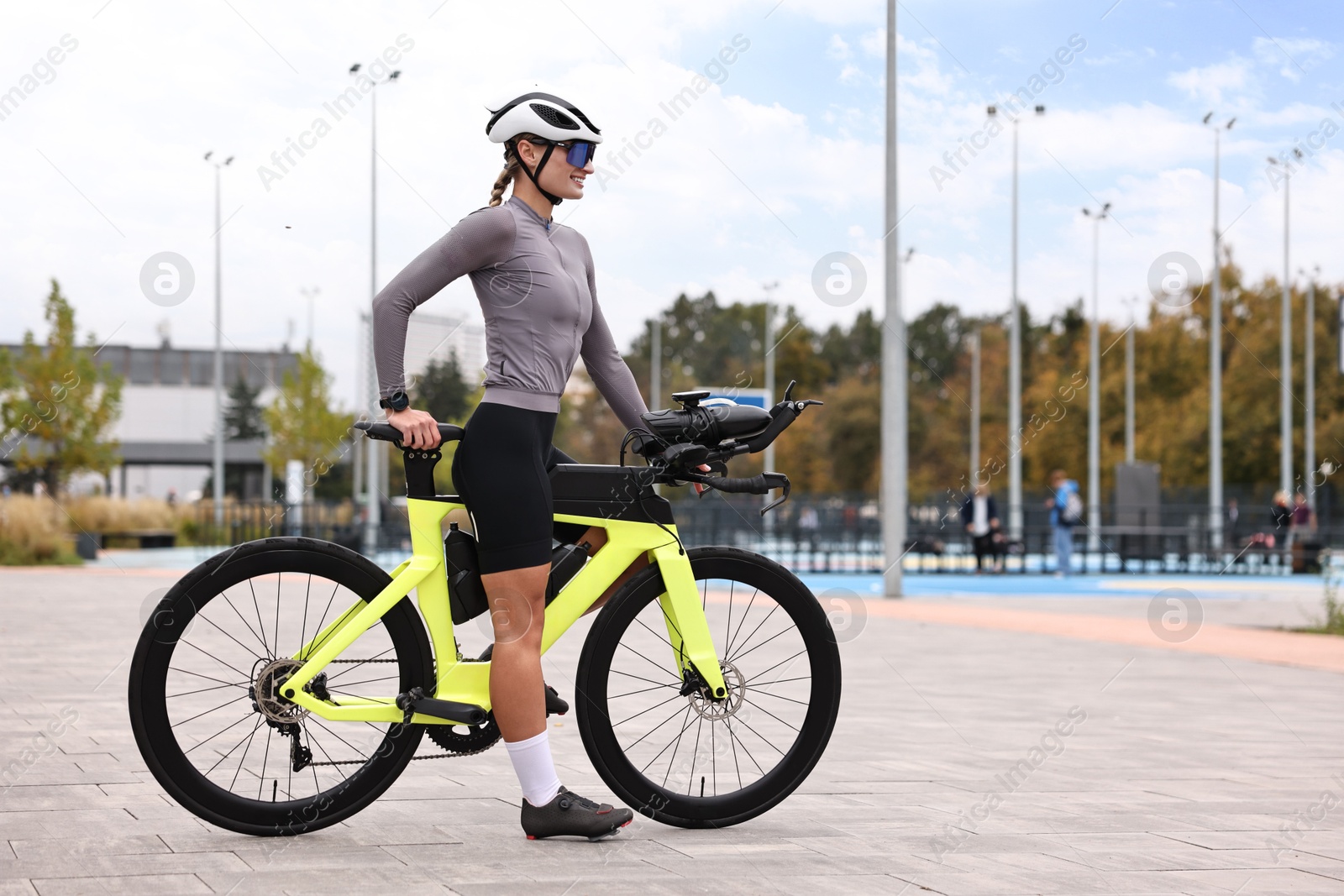 Photo of Young athletic woman with helmet and bicycle outdoors, space for text