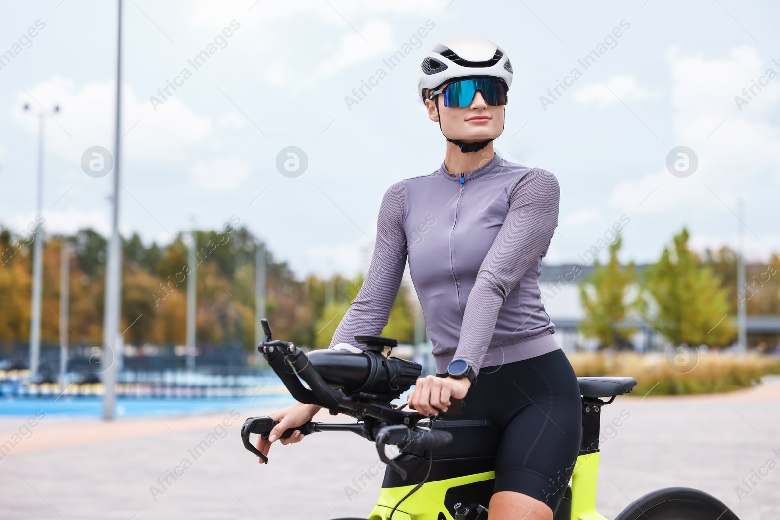 Photo of Young athletic woman with helmet and bicycle outdoors