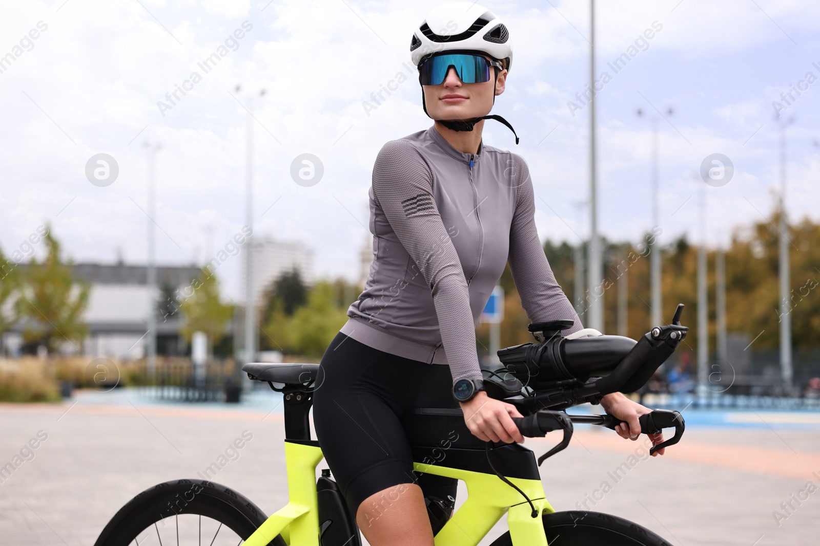 Photo of Young athletic woman with helmet and bicycle outdoors