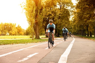 Photo of Group of athletic people riding bicycles outdoors