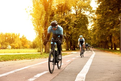 Photo of Group of athletic people riding bicycles outdoors