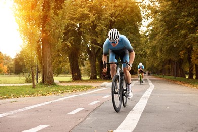 Photo of Athletic man with helmet riding bicycle outdoors, space for text