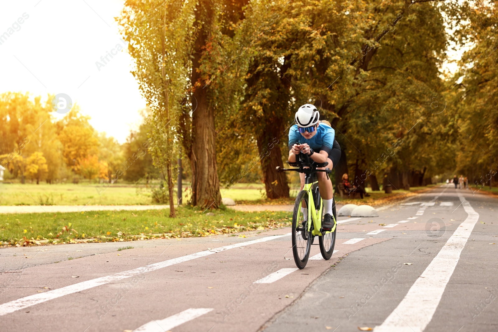 Photo of Athletic woman with helmet riding bicycle outdoors, space for text