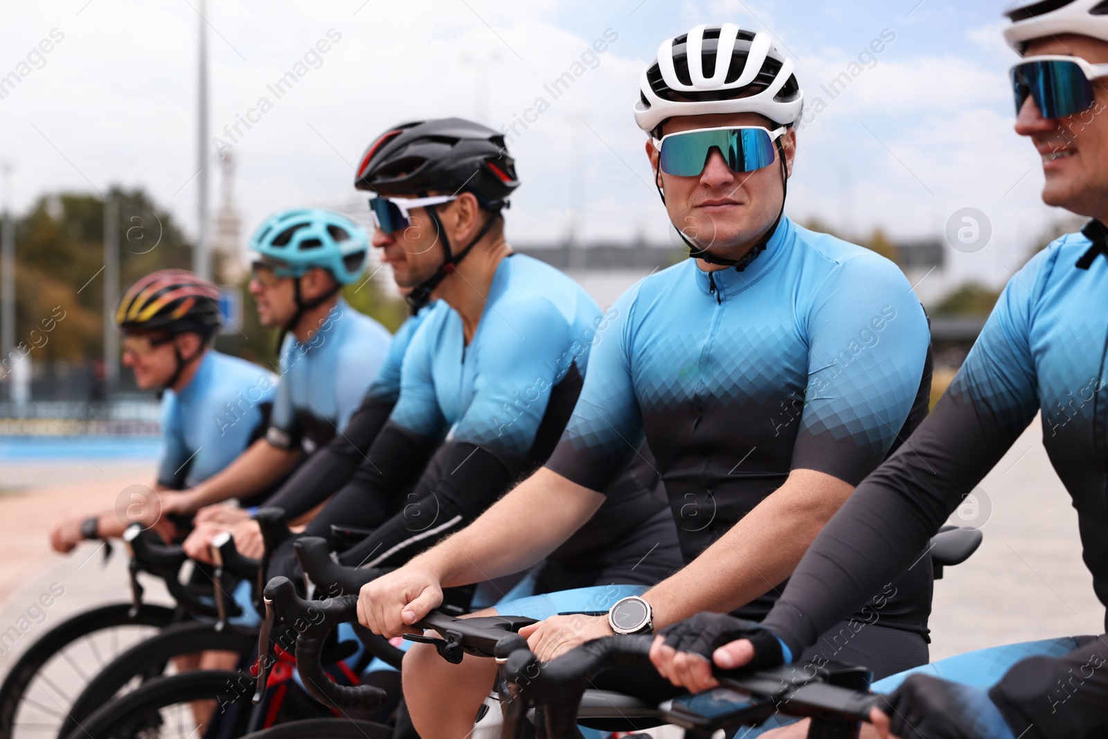 Photo of Group of athletic people with bicycles outdoors