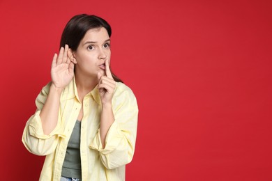 Photo of Woman showing hand to ear gesture on red background, space for text