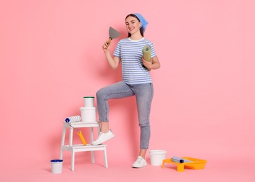 Photo of Young decorator with different tools on pink background