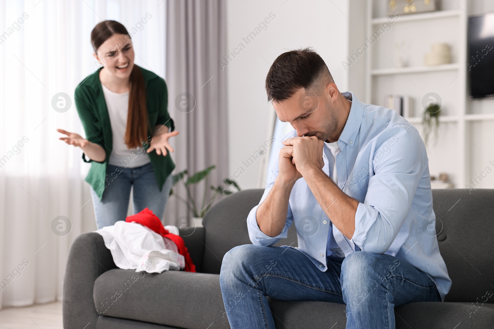 Photo of Husband ignoring his emotional wife at home, selective focus