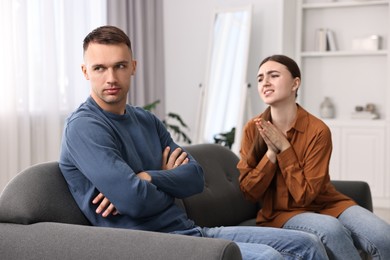 Photo of Wife apologizing her husband while he ignoring her at home, selective focus