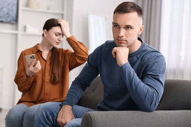 Photo of Upset couple after quarrel at home, selective focus