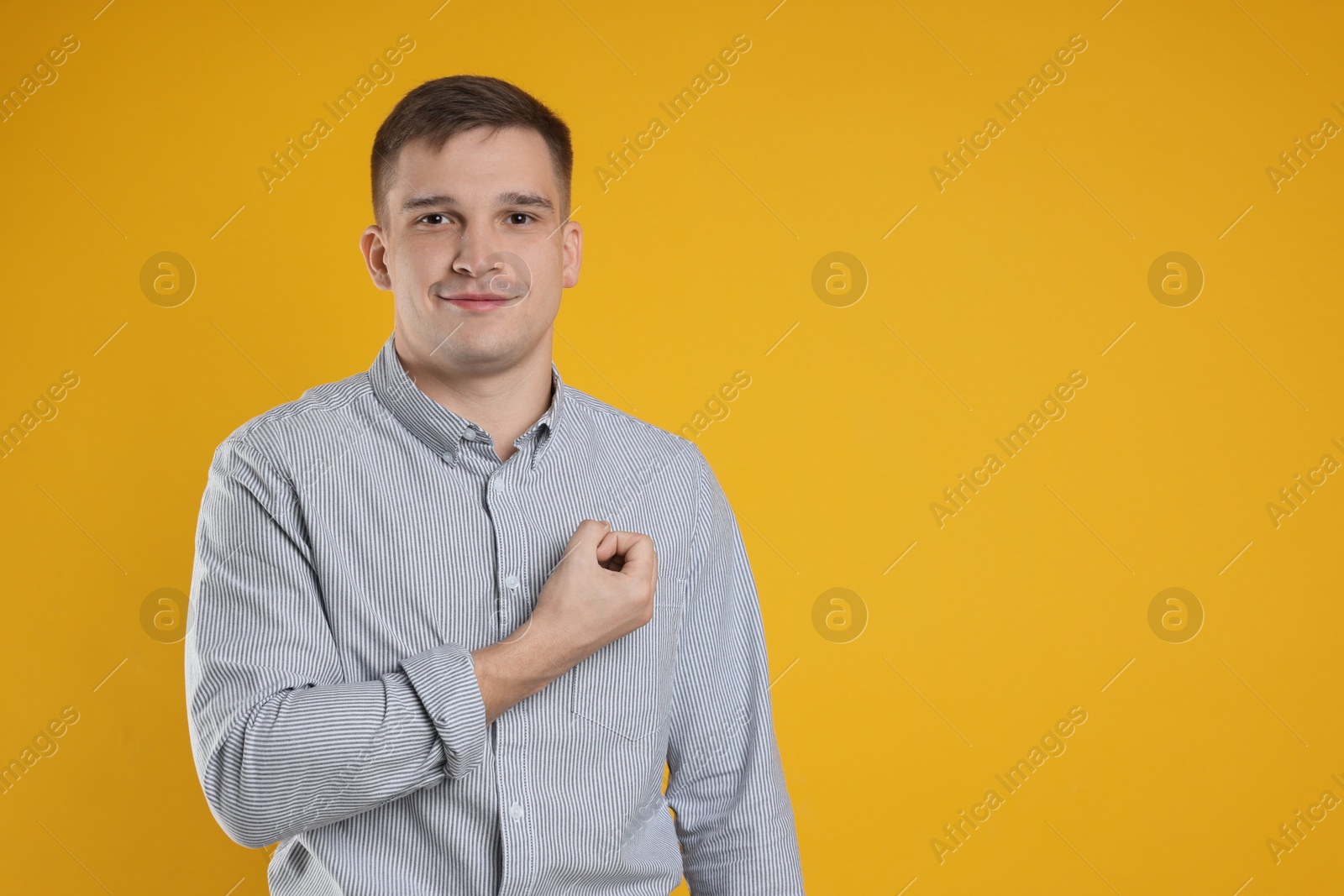 Photo of Man making promise on orange background, space for text. Oath gesture