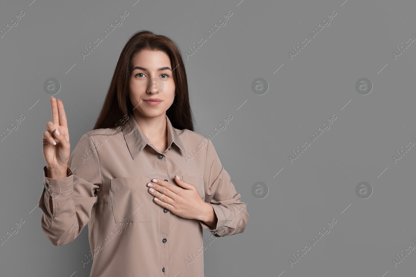 Photo of Woman showing oath gesture on grey background, space for text. Making promise