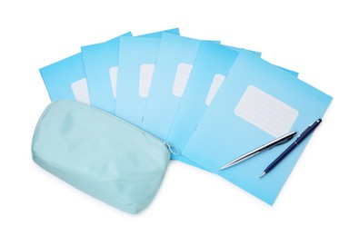 Photo of Copybooks, pencil case and pens isolated on white, top view. School stationery